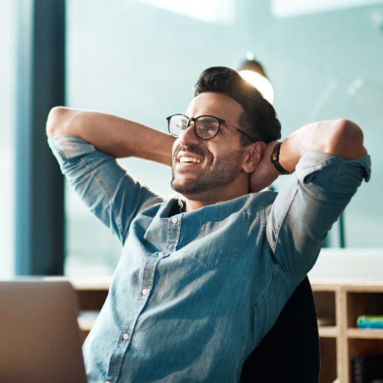 smiling man with glasses at his desk